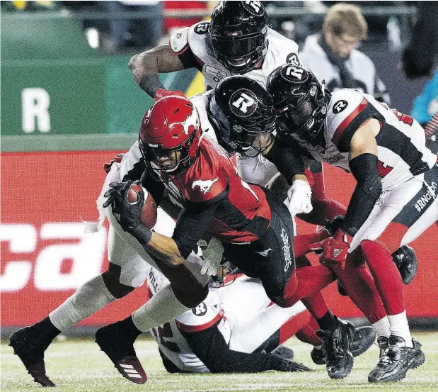  ?? DAVID BLOOM ?? Calgary Stampeders receiver Eric Rogers dives past a trio of Ottawa Redblacks during the first half of the Grey Cup game at Commonweal­th Stadium in Edmonton Sunday. After losing the last two Grey Cup games, the Stampeders bounced back to win this one, topping Ottawa 27-16.