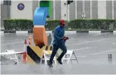  ?? — Photo by Shihab ?? A worker runs down the street, braving the rain at the Dubai World Trade Centre area.