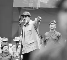  ??  ?? Maduro (centre) speaks during a ceremony with militia members at Miraflores Palace in Caracas. — Reuters photo