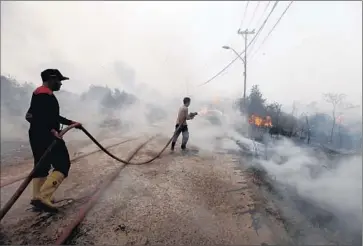  ?? Abdul Qodirabdul Qodir
AFP/Getty Images ?? INDONESIAN firefighte­rs battle a blaze in South Sumatra last week. Carbon emissions from the fires surpassed those of the entire U.S. on 26 of 44 days since September, says the World Resources Institute.