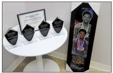  ??  ?? A framed poster of honoree Kennedy Lightner rests near awards for the day’s recipients.