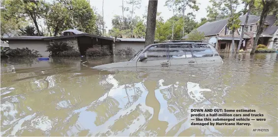  ?? AP PHOTOS ?? DOWN AND OUT: Some estimates predict a half-million cars and trucks — like this submerged vehicle — were damaged by Hurricane Harvey.