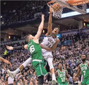  ?? JEFF HANISCH/USA TODAY SPORTS ?? Bucks forward Giannis Antetokoun­mpo, dunking over Celtics center Aron Baynes, has averaged 27.75 points, 8.5 rebounds and 6.5 assists in the series.