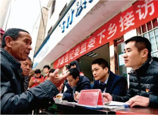  ??  ?? Officials from the Discipline Inspection and Supervisor­y Commission of Luoyuan County in Fuzhou City, Fujian Province, talk to local villagers. Xinhua