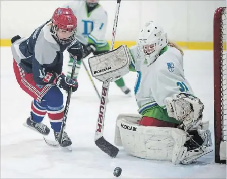  ?? PETER LEE RECORD STAFF ?? St. Mary’s Eagles’ Alex Bassanese, left, goes after a loose puck near the crease of St. David Celtics goaltender Mikayla Schnarr in first-period action in the first game of the District 8 girls’ hockey final played at RIM Park in Waterloo on Tuesday....