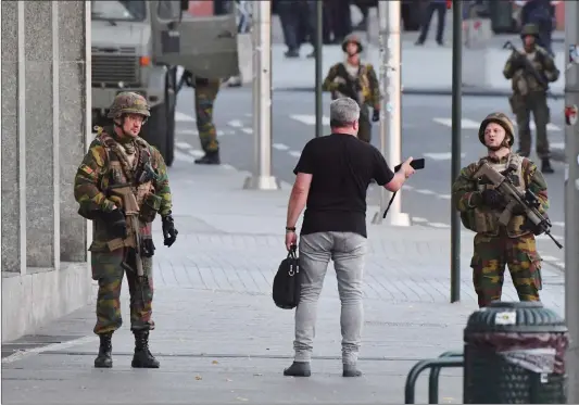  ?? Photo: IC ?? Belgian Army soldiers approach a man outside Central Station after a reported explosion in Brussels on Tuesday.