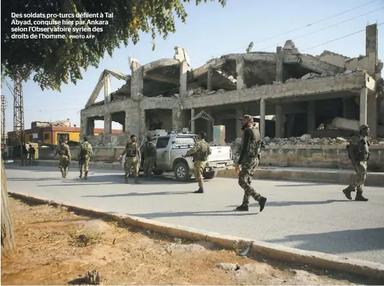  ?? PHOTO AFP ?? Des soldats pro-turcs défilent à Tal Abyad, conquise hier par Ankara selon l’Observatoi­re syrien des droits de l’homme.