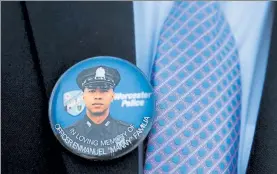  ?? NANCY LANE / BOSTON HERALD ?? A button with the image of Worcester Police Officer Enmanuel Familia, who died trying to save a drowning teen, is seen outside his funeral Mass on Thursday in Worcester,