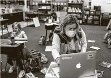  ?? Jose M. Osorio / Chicago Tribune ?? Sharon Nelles, a literacy coordinato­r in Arlington Heights, Ill., gets a computer up and running in a classroom at Patton Elementary on Thursday. Nelles was serving as a substitute.