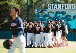  ?? D. ROSS CAMERON/AP ?? UConn’s T.C. Simmons walks off, as Stanford players celebrate their victory and the trip to the College World Series last June. The Huskies have a lot of new players, but the hunger to get to Omaha remains. The new season begins in three weeks.