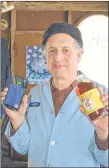  ?? PAUL STROME ?? Neal Livingston holds up a bottle of maple syrup next his smart phone. The syrup producer says he has increased his annual yield thanks in part to app technology that can detect leaks in his sap lines.