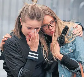  ??  ?? Two tearful women join a vigil of thousands near Tower Bridge yesterday