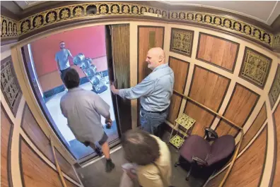  ?? MARK HOFFMAN / MILWAUKEE JOURNAL SENTINEL ?? James Wodke drops off passengers while a delivery person waits to take the elevator to the ground floor at the Century Building, 808 N. Old World 3rd Street in Milwaukee. Once renovation­s are completed to the circa 1925 building, Wodke will no longer own the distinctio­n as the only elevator operator in Milwaukee who guides the car to manually stop at each floor. The elevator will be replaced with an automated one.