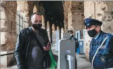  ?? DOMENICO STINELLIS / AP ?? A visitor has his temperatur­e checked as he arrives at the Colosseum in Rome on April 27. The ancient Roman gladiator arena reopened after being closed for 41 days due to COVID-19.