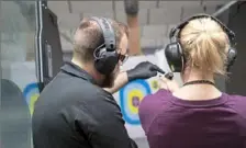  ?? Emily Matthews/Post-Gazette ?? Alexander Onisa, a range safety officer and gunsmith at Keystone Shooting Center in Cranberry, shows Stefanie Bova, of Couderspor­t, how to shoot on Wednesday at the shooting facility.