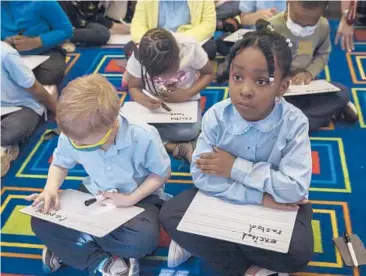  ?? THALIA JUAREZ/THE NEW YORK TIMES ?? First-graders work on spelling and writing April 14 at an elementary school in the Brooklyn borough of New York City.