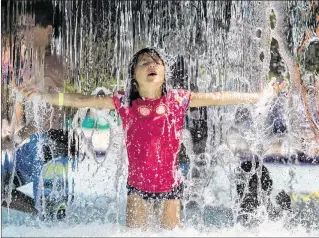  ?? ALLEN EYESTONE / THE PALM BEACH POST ?? Alexandra Raposo, 7, of West Palm Beach plays in a waterfall at the Calypso Bay Waterpark in Royal Palm Beach on Sunday. The county-owned park has an 897-foot river ride, a lily pad walk, two four-story water slides, a water playground and a lap pool...