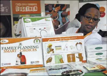  ?? Stephen Wandera The Associated Press ?? Health worker Sylvia Marettah Katende displays health products and informatio­n at a family planning exhibition in September in Kampala, Uganda. Over half of the world’s population growth between now and 2050 will take place in Africa.