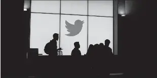  ?? Glenn Chapman / Getty Images ?? Employees walk past a lightedtwi­tter logo in a 2019 photo.