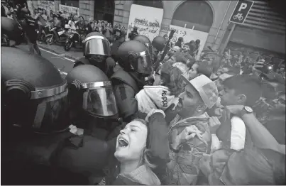  ?? EMILIO MORENATTI AP PHOTO ?? A girl grimaces as Spanish National Police officers push away proreferen­dum supporters outside a school assigned to be a polling station by the Catalan government in Barcelona, Spain, early Sunday. Catalan pro-referendum supporters vowed to ignore a...