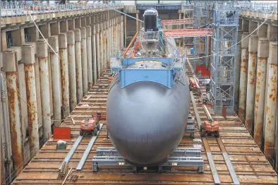  ?? Jessica Hill / Associated Press file photo ?? Shipyard workers at General Dynamics’ Electric Boat prepare the submarine Illinois for float-off in Groton in 2015.