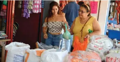 ?? FOTOS: LA PRENSA ?? VENTA. Una mujer se abastece de granos básicos en un mercado de San Pedro Sula.