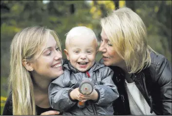  ?? NIKLAS LARSSON/THE ASSOCIATED PRESS ?? Albin’s mother Emelie Eriksson, left, smiles Sept. 20 with her son and her mother, Marie, outside her home in Bergshamra, Sweden. Eriksson was the first woman to have a baby after receiving a womb transplant from her mother, a revolution­ary operation...