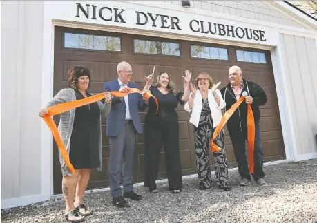  ?? DAN JANISSE ?? Christine Gaudet, left, Dave Dyer, Kaitlyn Dyer, Kim Dyer and Germain Gaudet cut a ceremonial ribbon on Friday at the Nick Dyer Clubhouse in Windsor. The clubhouse on Baseline Road will house the Julien's House charity's peer-to-peer grief support programs.