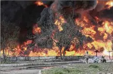  ?? Associated Press ?? Firefighte­rs battle an inferno at an oil depot after missiles struck the facility Wednesday in an area that is controlled by Russian-backed separatist forces in Makiivka, eastern Ukraine.