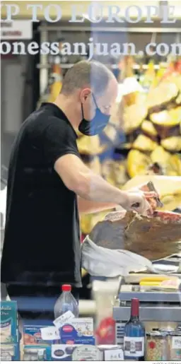  ?? JAVIER ALBIÑANA ?? Un trabajador, en una tienda de alimentaci­ón.