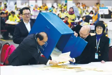  ?? PARKER ZHENG / CHINA DAILY ?? Electoral Affairs Commission (EAC) Chairman Barnabas Fung Wah (first from left) empties a ballot box with EAC staff at the counting station of the Election Committee at Asia-World Expo on Monday. As of 9:30 pm on Sunday, the turnout stood at a record...