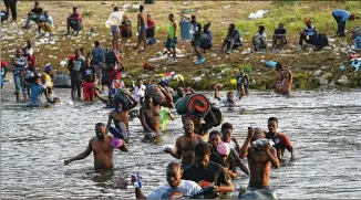  ?? FERNANDO LLANO/ASSOCIATED PRESS ?? Migrants, many from Haiti, wade the Rio Grande from Del Rio, Texas, to return to Ciudad Acuna, Mexico, on Tuesday to avoid deportatio­n from the U.S., which is flying Haitians camped in a Texas border town back to their homeland and blocking others from crossing the border from Mexico.