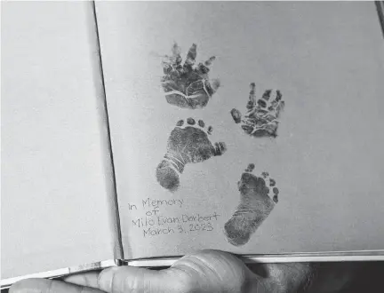  ?? LUIS SANTANA TNS ?? Deborah Dorbert holds open a page of the book “I'll Love You Forever” with the hand and footprints of their son Milo Evan Dorbert, who passed away in March 2023.