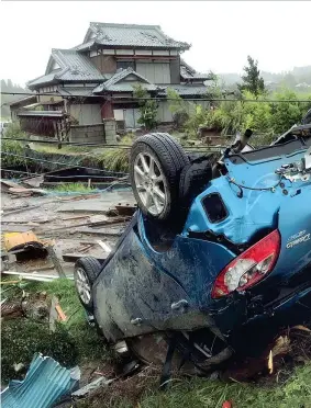  ??  ?? Auto ribaltate e case distrutte vicino a Tokyo dalla furia del tifone Hagibis che sta spazzando il Giappone