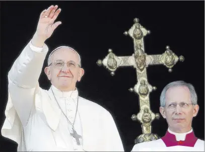  ?? Alessandra Tarantino ?? The Associated Press Pope Francis, flanked by Master of Ceremonies Bishop Guido Marini, waves to faithful during the “Urbi et Orbi” blessing on Christmas Day from the main balcony of St. Peter’s Basilica at the Vatican.