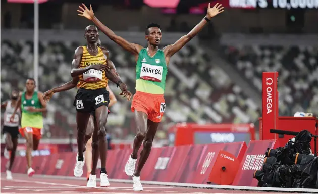  ?? Agence France-presse ?? ↑
Ethiopia’s Selemon Barega (right) celebrates after winning the men’s 10,000m final at the Olympic Stadium on Friday.