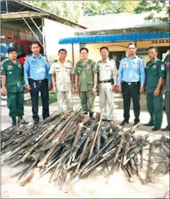  ?? SWIFTNEWS ?? Officials pose with homemade rifles confiscate­d and voluntaril­y handed over by villagers in Siem Reap province on Wednesday.