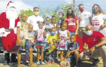  ??  ?? Briana Williams, World Championsh­ips Under-20 double gold medallist (back row, third right), pose with a group of children who were presented with toys during a treat held in the Paradise and Norwood areas of St James on Sunday. Also in the photo is Elon Parkinson (from right), public relations and communicat­ions manager at Digicel.