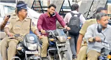  ?? —S. SURENDER REDDY ?? Cops return from a briefing on security arrangemen­ts for the Opposition­sponsored ‘Chalo Dharna Chowk’ rally without wearing helmets and one of them even talking on the phone while riding his bike.