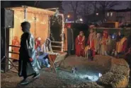  ??  ?? Clinton Azagba, 17, playing Joseph and Ayo Tunde-Sanya, also 17, playing Mary, receive gifts from the wise men as the shepherds look on in the chilly night during the First Baptist Church’s annual live Nativity in Savage, Maryland.