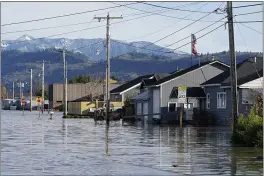  ?? ELAINE THOMPSON — THE ASSOCIATED PRESS FILE ?? Floodwater inundates homes along a road on in Sumas, Wash.