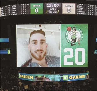  ?? STAFF PHOTOS BY CHRISTOPHE­R EVANS (ABOVE) AND MATT STONE ?? ON THE BOARD: Marcus Smart (below) gestures toward the video screen high above center court as Gordon Hayward makes a surprise appearance from his hospital room during last night’s pregame ceremony at the Garden.