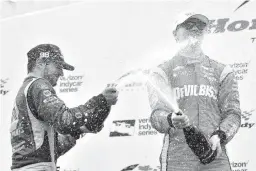  ?? Associated Press ?? n Winner Josef Newgarden, right, and second place finisher Alexander Rossi spray each other with sparkling wine on Sunday following the Honda Indy Toronto.