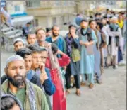  ?? AGENCIES ?? BUZZ IN KABUL: (L-R) A child carries loaves of bread; people queue up outside a bank; a Taliban member stands guard in front of the internatio­nal airport; and women cross a street.