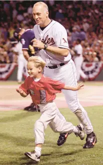  ?? STEPHEN JAFFE/GETTY-AFP ?? The Orioles’ Cal Ripken Jr. chases after his son, Ryan, as they run to the dugout during a break in the 1999 All-Star Game at Fenway Park in Boston.