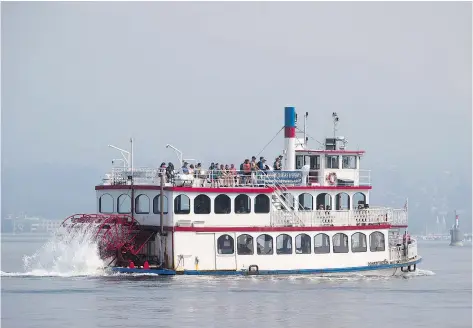  ?? — THE CANADIAN PRESS ?? Smoke from wildfires burning in central British Columbia hangs in the air as tourists explore the harbour on the Constituti­on paddlewhee­l boat in Vancouver on Thursday.