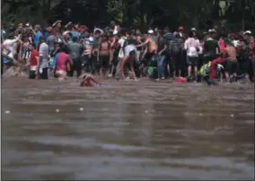  ?? SANTIAGO BILLY — THE ASSOCIATED PRESS ?? A new group of Central American migrants bound for the U.S border, reach the shore on the Mexican side of the Suchiate River after wading across from Tecun Uman, Guatemala, Monday. The first group was able to cross the river on rafts — an option now blocked by Mexican Navy river and shore patrols.