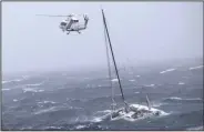  ?? (AP/New Zealand Defense Force) ?? A helicopter from the HMNZS Te Mana locates a yacht in distress Tuesday, in the Hauraki Gulf off New Zealand’s North Island with a solo sailor on board.