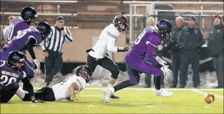  ??  ?? Merrillvil­le’s Nick Price, right, scrambles for a Warsaw fumble during the game.