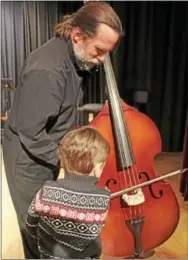  ?? CHRIS BARBER — DIGITAL FIRST MEDIA ?? A child tries his hand at the cello after the symphony concert on Sunday.